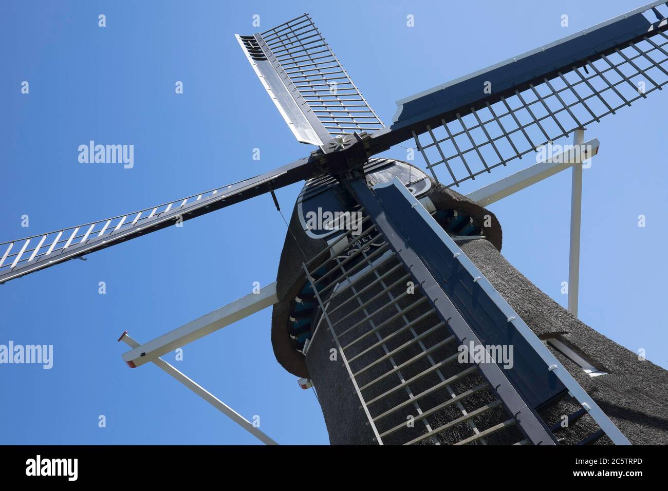 Primo piano di un mulino a vento olandese contro un cielo blu Foto Stock