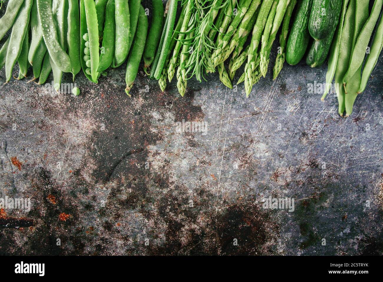 Gruppo di verdure verdi in fila, piatto su pietra grigia, spazio copia Foto Stock