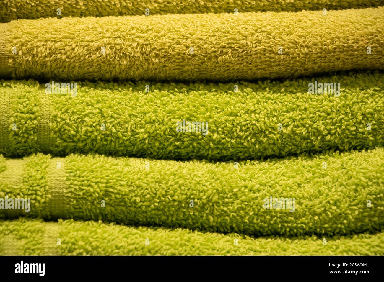 Texture di verde spugna asciugamani primo piano. Una pila di accessori per bagno morbidi. Foto Stock