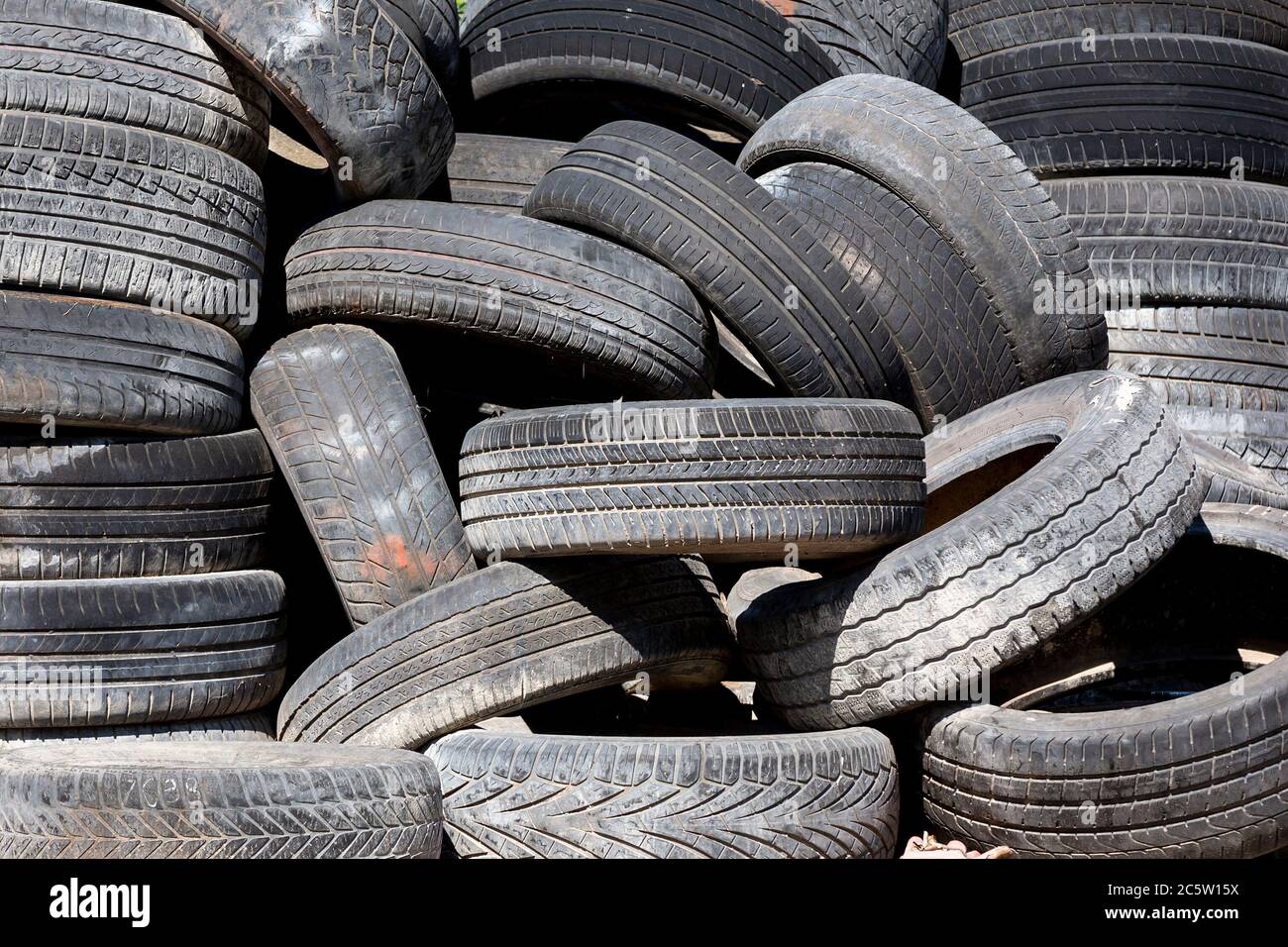 Pneumatici di auto vecchie e usate su un palo. Foto Stock
