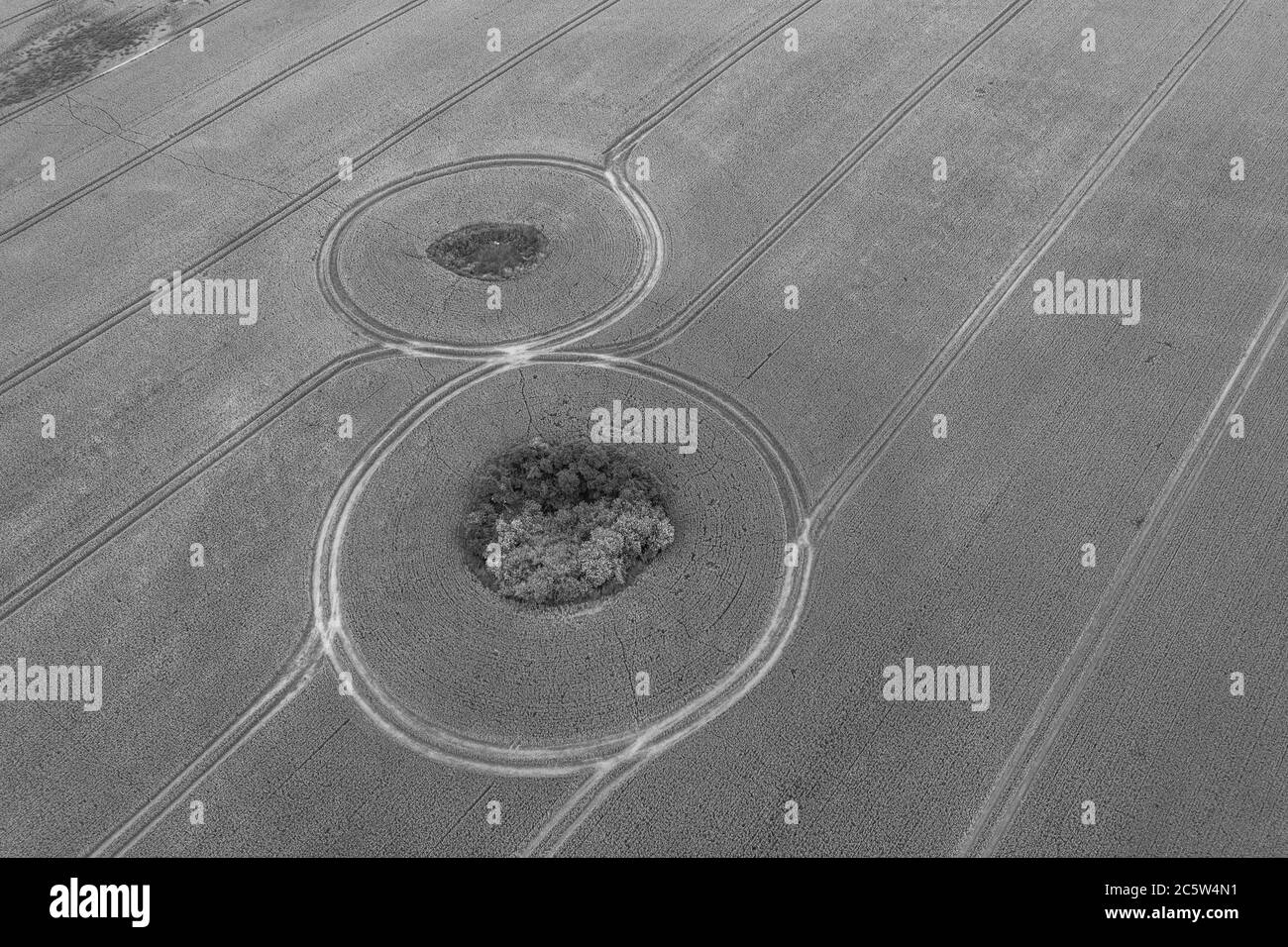 una fotografia con drone da un campo di grano mostra i cingoli del trattore a forma di otto Foto Stock