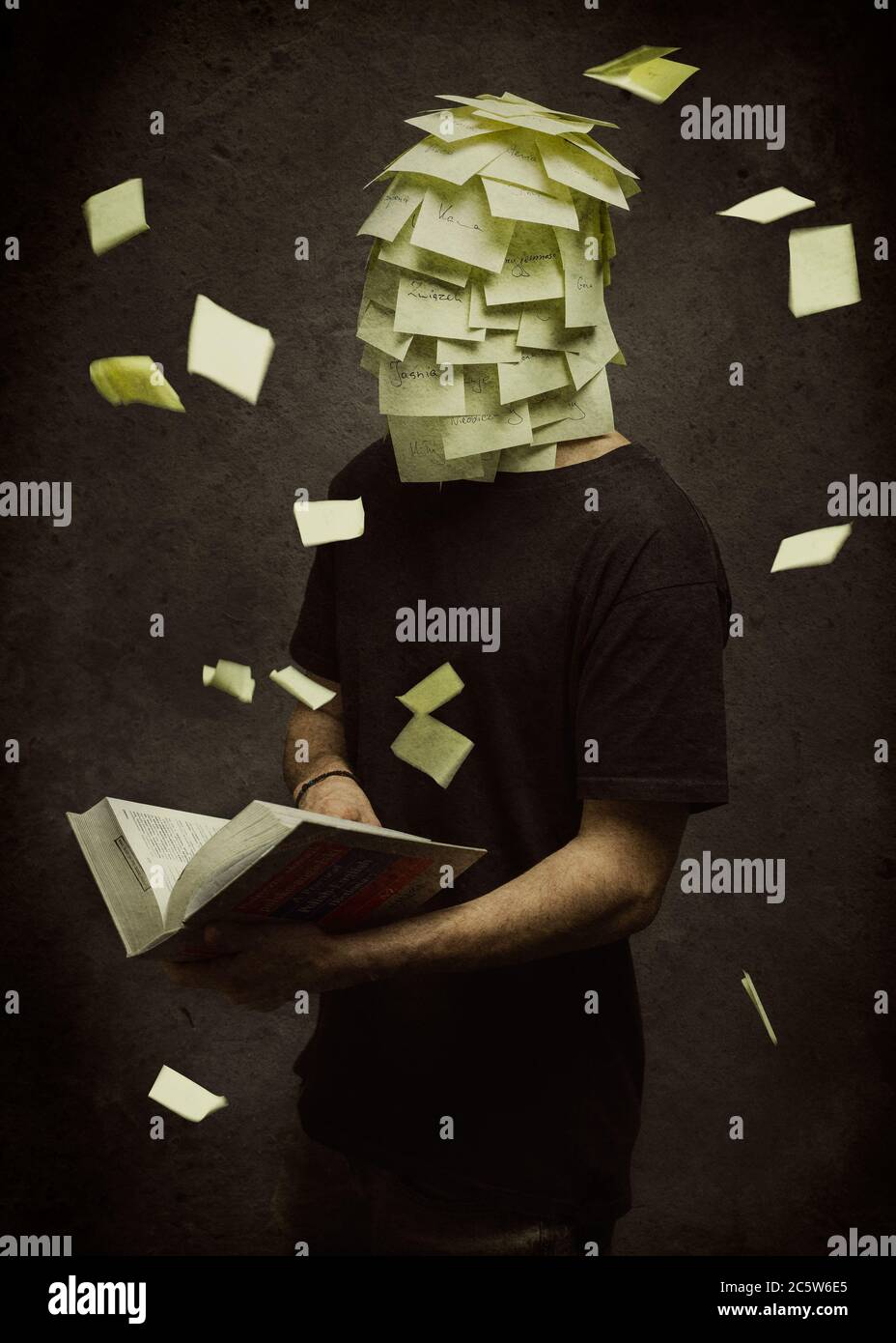 Un ragazzo alla ricerca di una traduzione in un dizionario di cui la testa è completamente coperta con note post-it Foto Stock