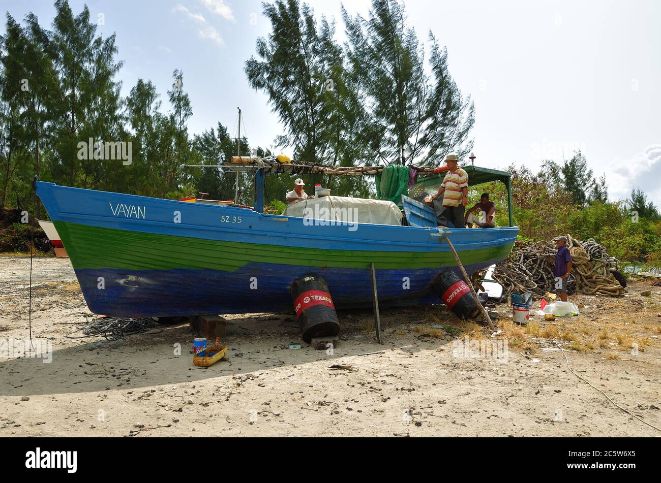 Mahe, Seychelles - 27 giugno 2011: I pescatori locali riparano una barca. La pesca è una parte importante dell'industria delle Seicelle Foto Stock