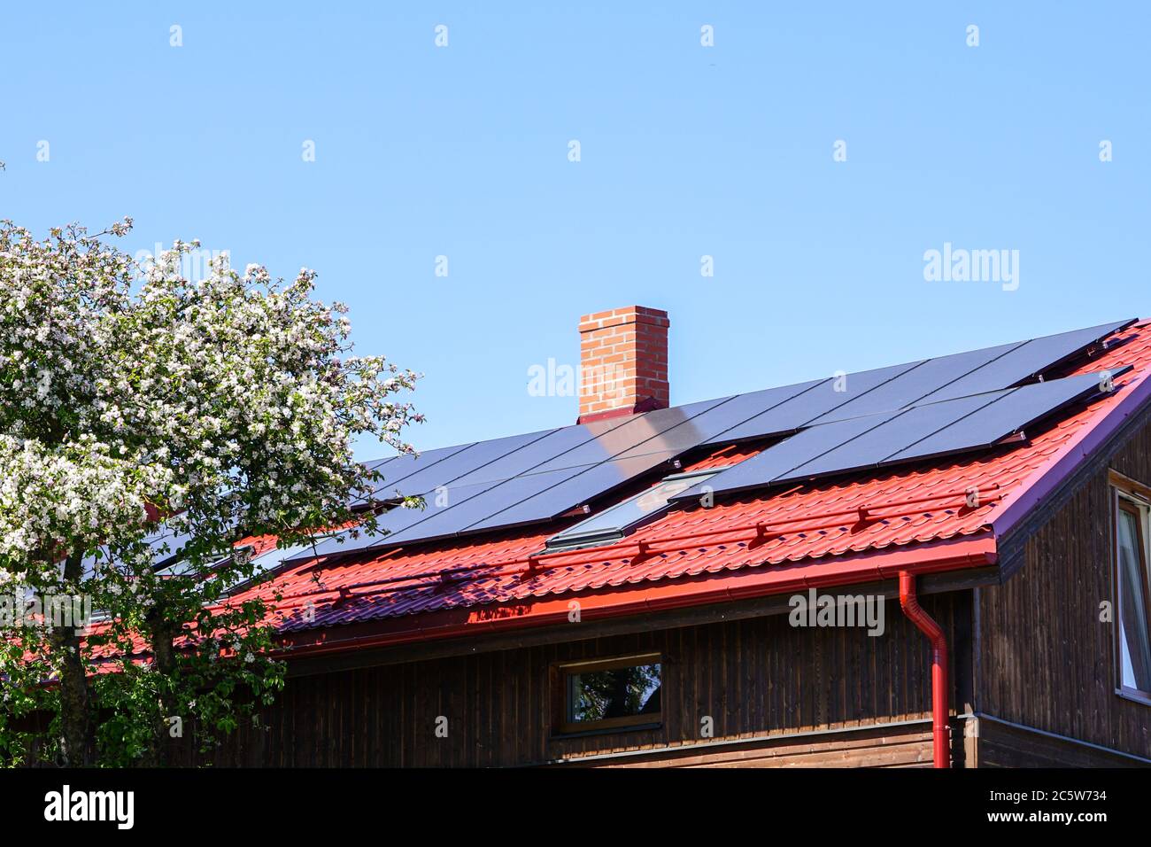 Pannelli solari su un tetto rosso della casa moderna Foto Stock