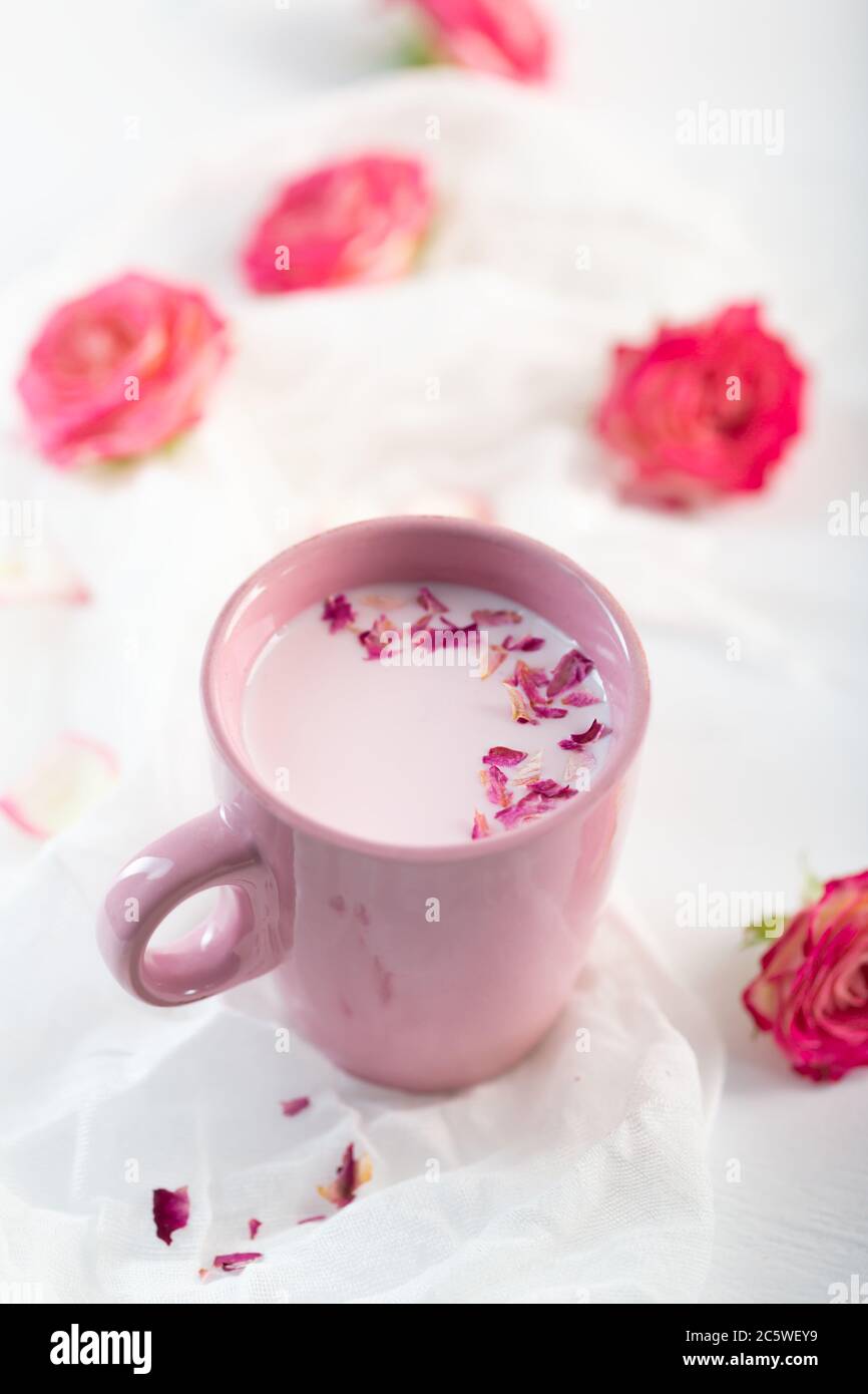 Latte lunare si prepara con rosa fiore. Drink rilassante alla moda a base di tradizioni ayurvediche Foto Stock