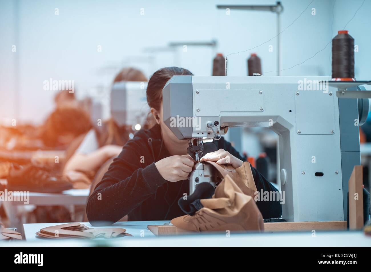 donna lavora con macchine da cucire in fabbrica di scarpe Foto Stock