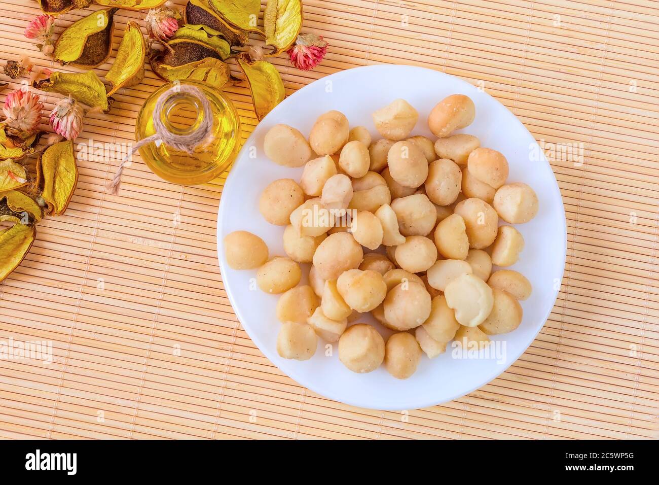 Ciotola di olio di noci e noci di macadamia, concetto di cibo sano, vista dall'alto Foto Stock