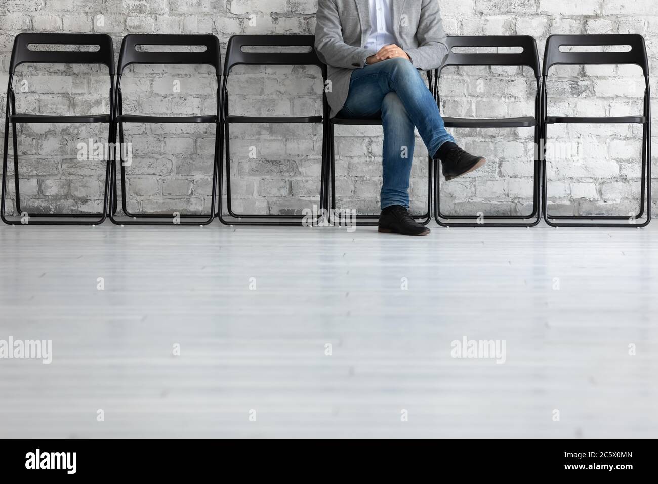 Uomo irriconoscibile seduto sulla sedia aspetta per turno intervista di lavoro Foto Stock