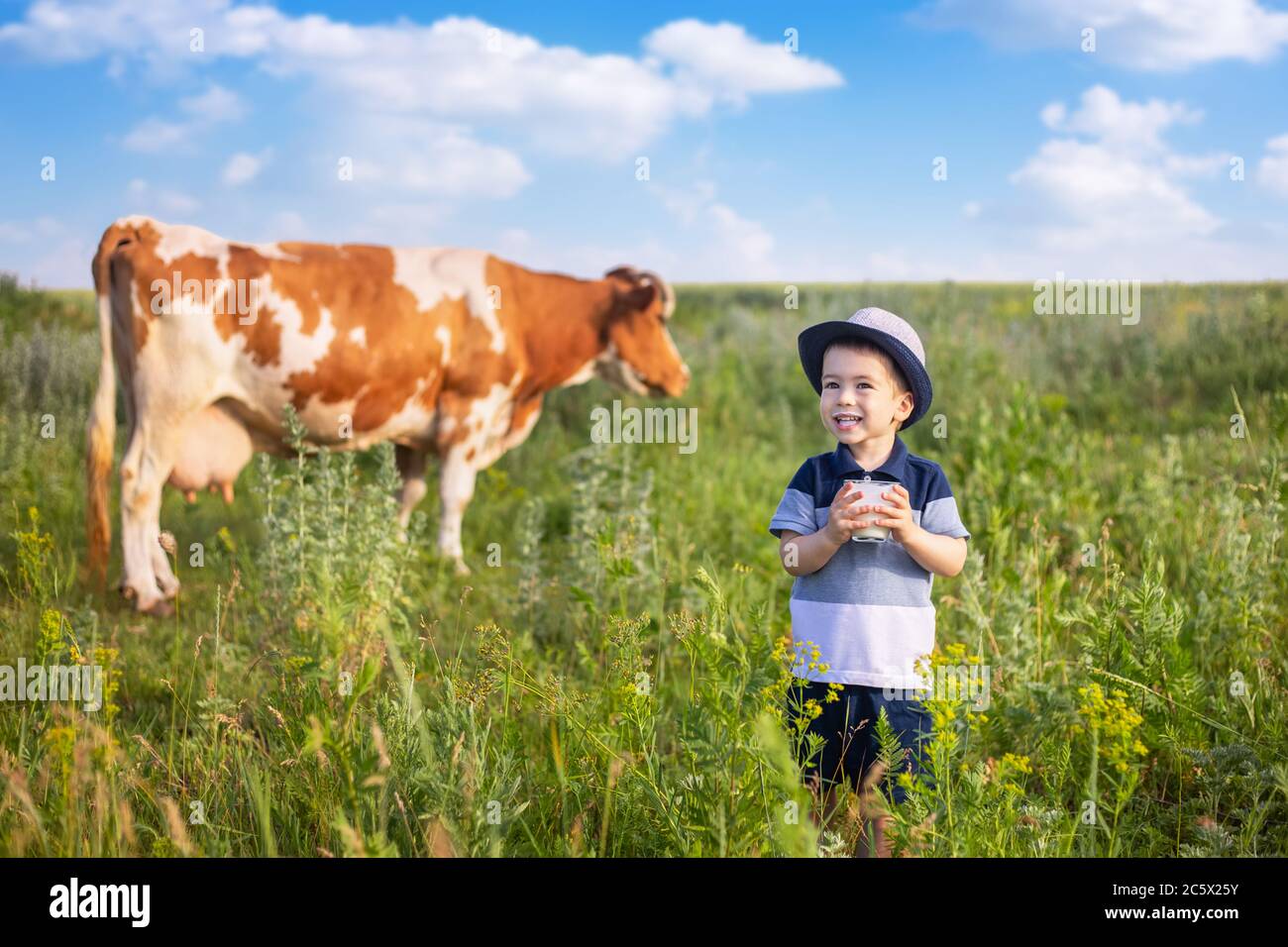 piccolo ragazzo che beve yogurt all'aperto Foto Stock