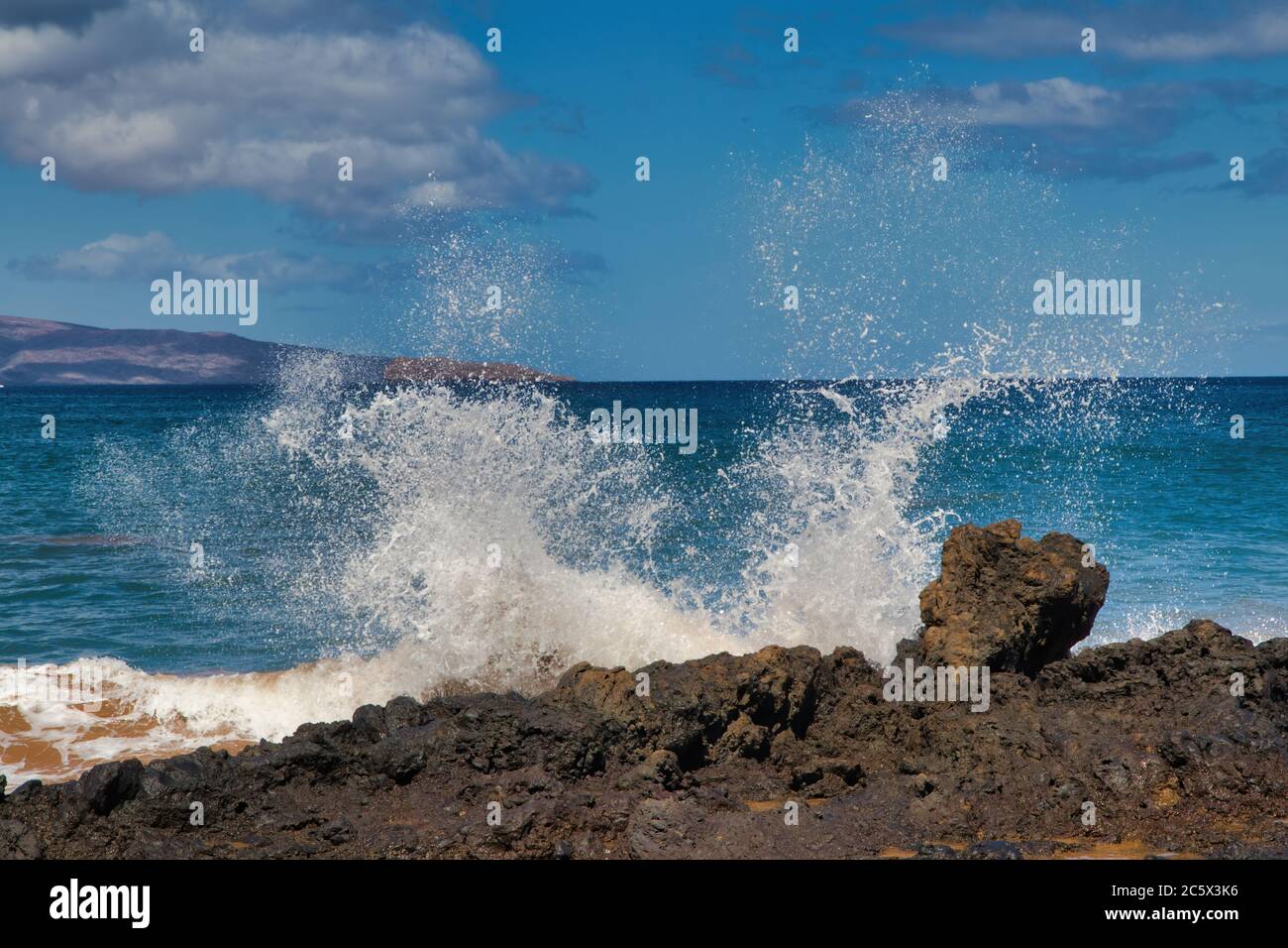 Onde che si schiantano contro la roccia vulcanica su Maui. Foto Stock