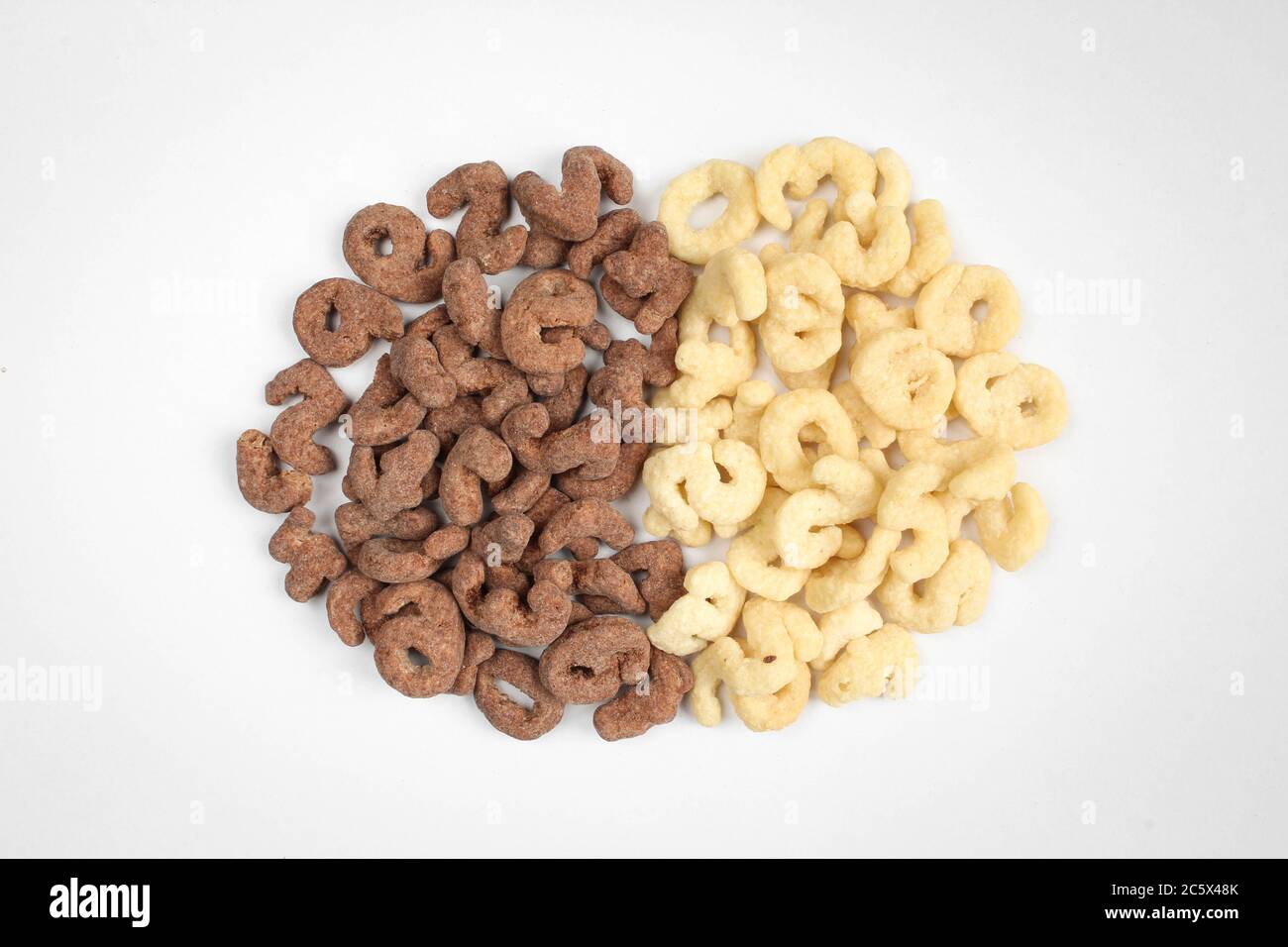 Cereali assortiti, vista dall'alto. Mucchio di scaglie di cioccolato bianco e nero. Colazione sana Foto Stock