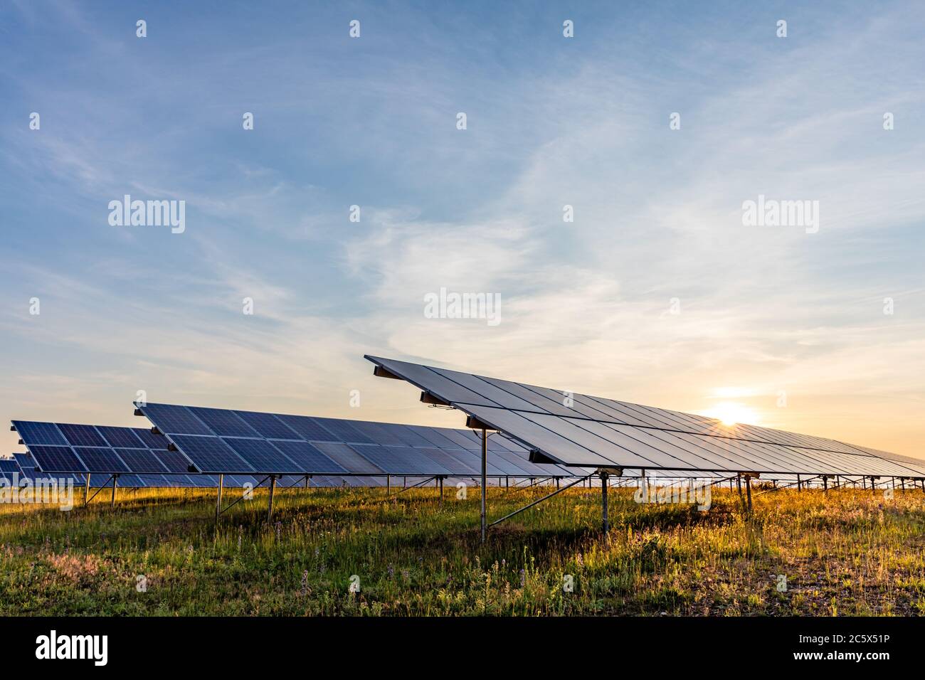 centrale fotovoltaica montata a terra al tramonto Foto Stock