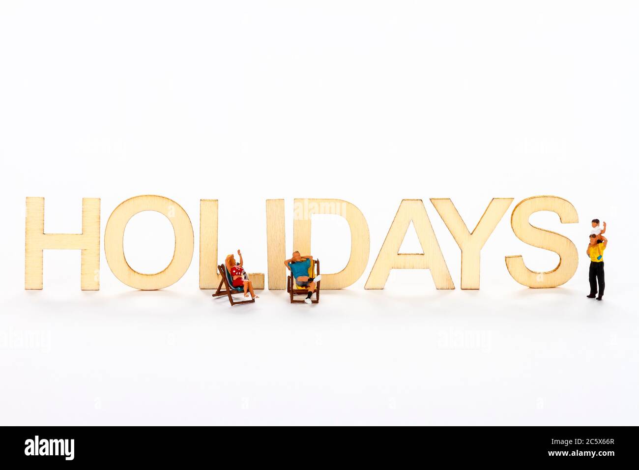 Cartello di vacanza in legno con figure in miniatura persone sedette su sedie a sdraio Foto Stock