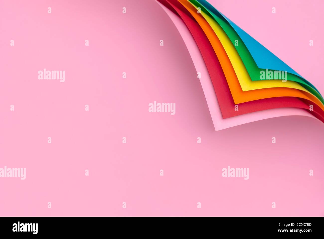 Carta colorata arcobaleno con angoli arricciati. Risma di carta multicolore e angoli piegati. Pagine con curva d'angolo. Foto Stock