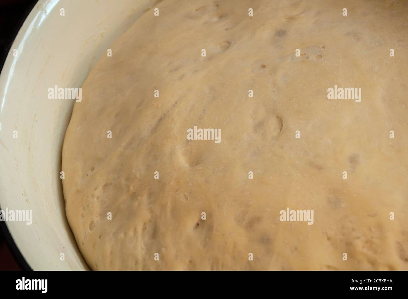 Pasta di lievito su polpette, raffigurato l'impasto in una grande ciotola, l'impasto rosato bene. Foto Stock