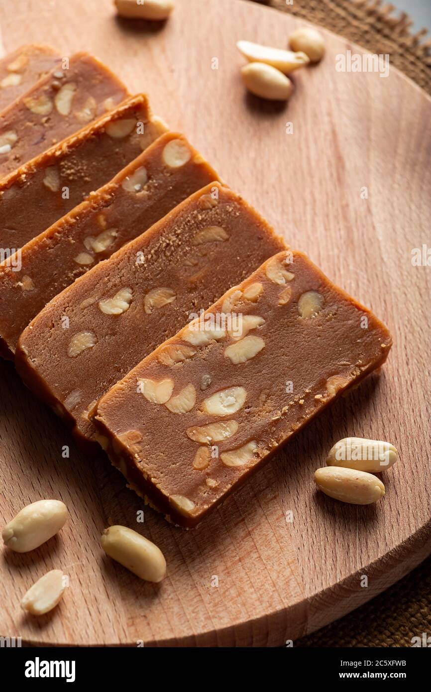 Toffee fatto in casa sulle arachidi su un asse di legno. Fette di dolci orientali con noci. Foto Stock