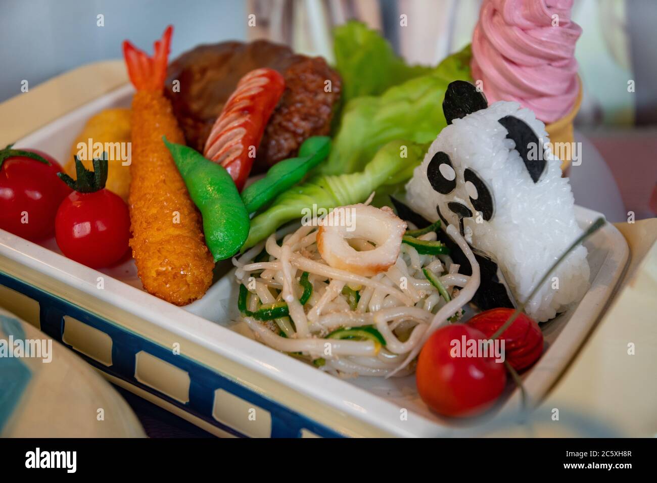 Primo piano su un menu per bambini con gamberi, verdure, onigiri panda a forma di orso e gelato. Cibo artificiale fatto da cera. Vetrina. Kappabashi Foto Stock