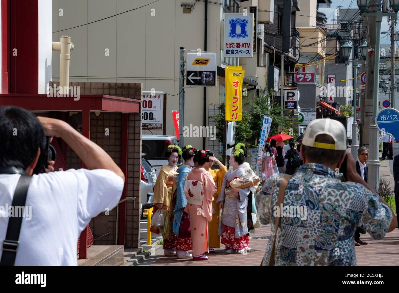 Gruppo di maiko appena fuori dal teatro Minami-za (il principale teatro kabuki in città) e paparazzi fotografandoli. Kyoto, Giappone Foto Stock