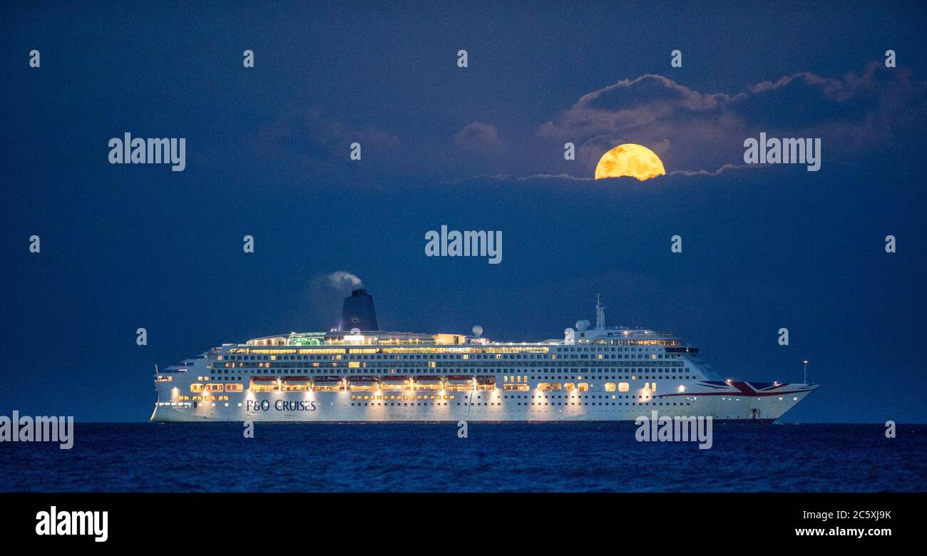 Bournemouth, Regno Unito. 5 luglio 2020. La luna piena di luglio, anche conosciuto come la Luna Buck sorge sopra la nave da crociera P&o Aurora all'ancora a Poole Bay al largo della costa Dorset. Credit: Richard Crease/Alamy Live News Foto Stock