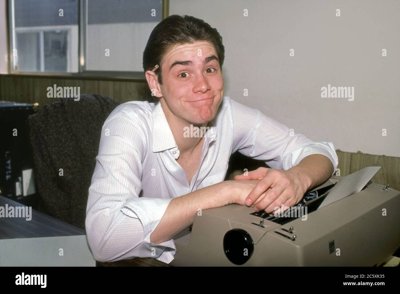 Un giovane Jim Carrey alla scrivania dell'ufficio come finge essere un produttore al lavoro. Foto Stock