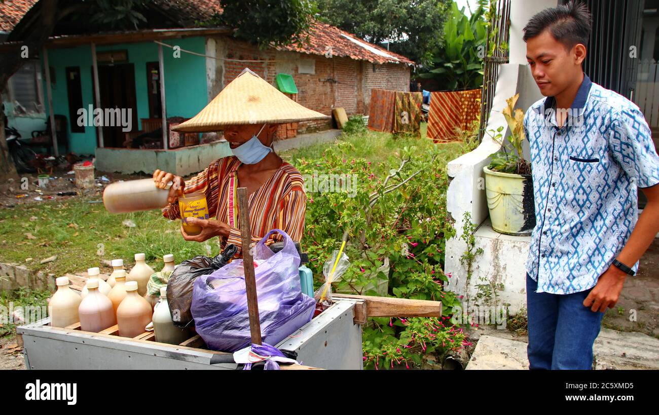 Venditore tradizionale di medicinali a base di erbe per la preparazione di una bevanda jaunya in un bicchiere, Pekalongan Indonesia, 15 aprile 2020 Foto Stock