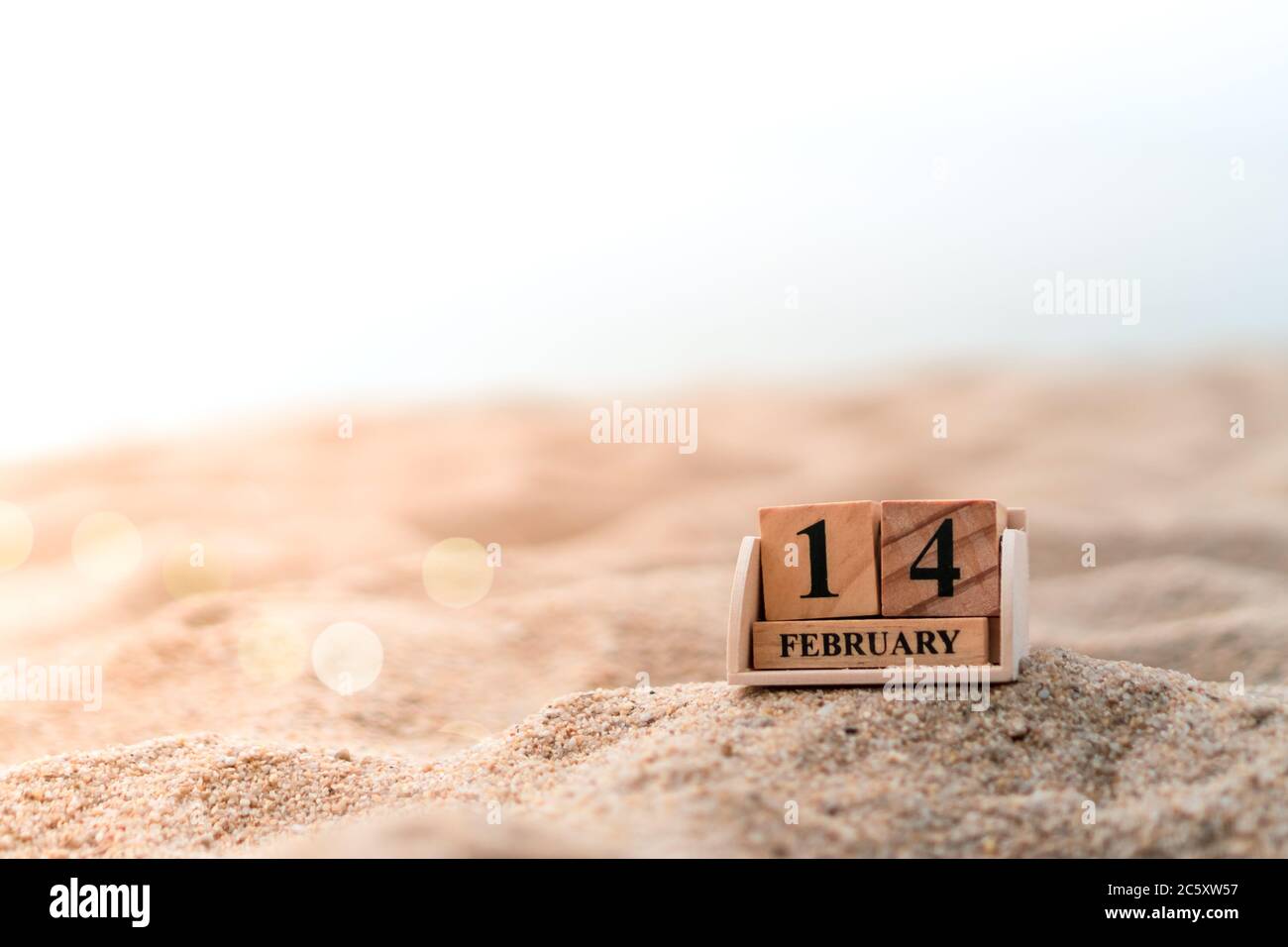 Blocco di legno mostra data e calendario mese del 14 febbraio o San Valentino. Concetto di festa e di stagione del weekend lungo. Foto Stock
