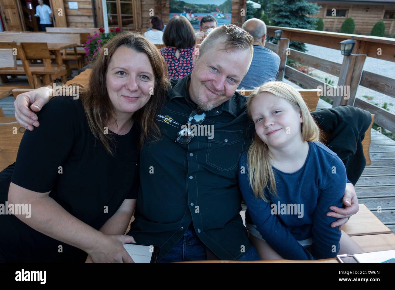 Famiglia felice che posa e sorride al ristorante Karczma Spalska all'aperto. Spala Polonia Centrale Foto Stock