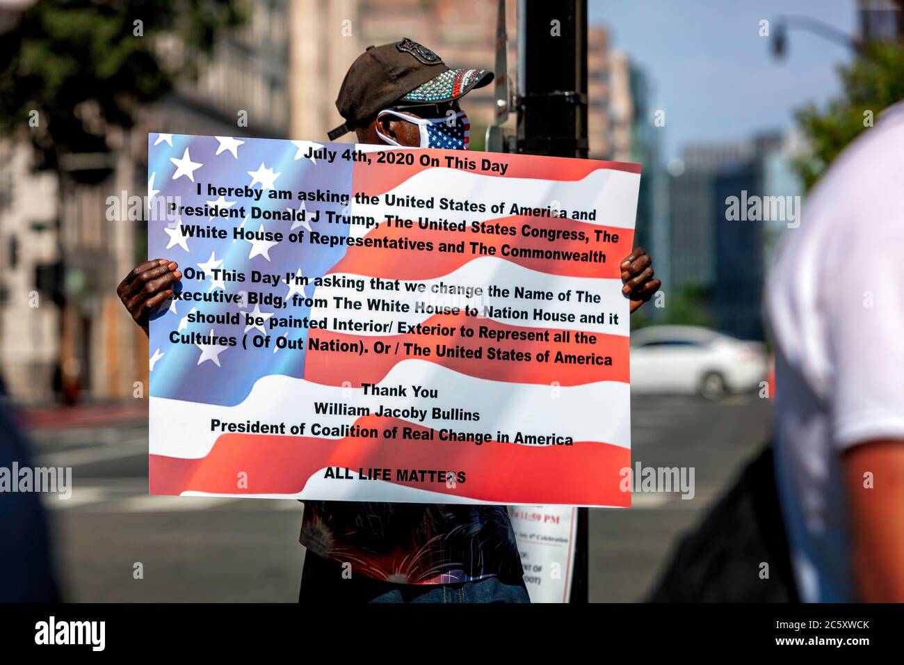 Il protestore con il segno fuori Black Lives Matter Plaza che sollecita che la Casa Bianca sia dipinta tutti i colori del popolo americano, Washington, DC, USA Foto Stock