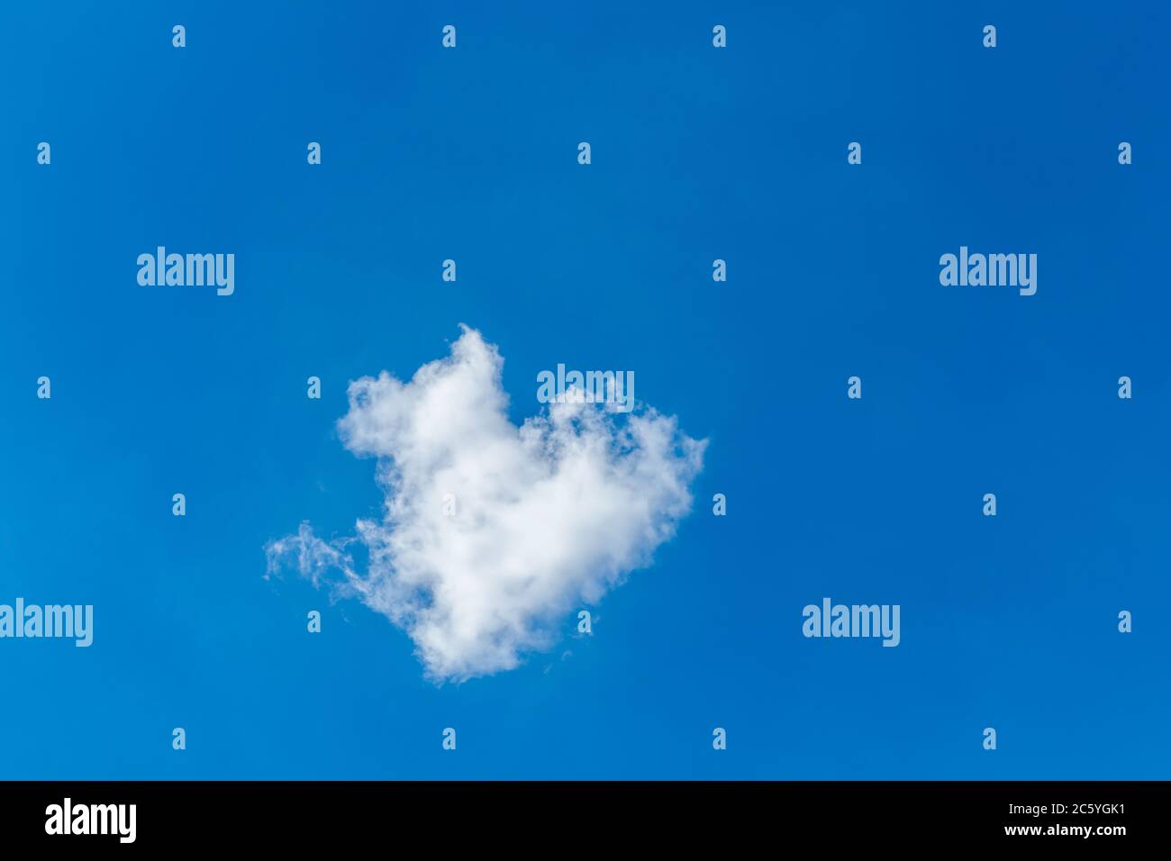 Romantica nuvola solitaria a forma di cuore su un cielo blu. Concetto di amore. Foto Stock