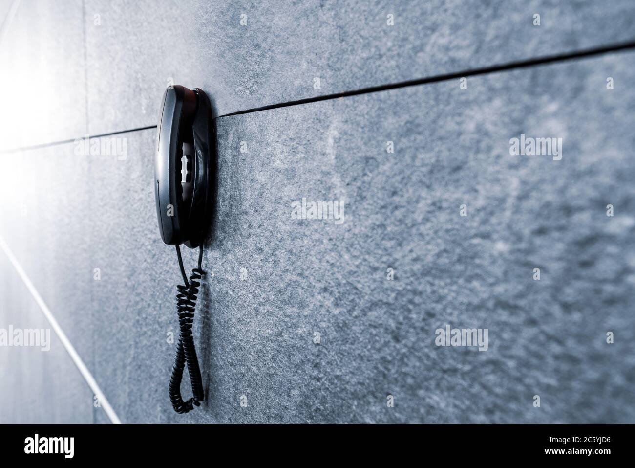 Un emetency o un telefono pubblico appendono su una bella parete di marmo decorata. Foto di alta qualità Foto Stock