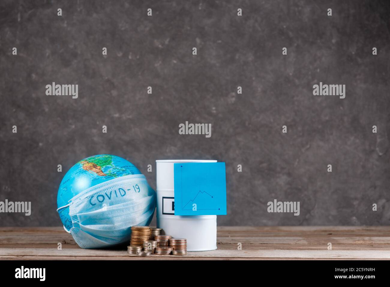 crisi finanziaria del petrolio sul pianeta associata all'epidemia. globo con una bandage e un barile di petrolio con un calendario Foto Stock