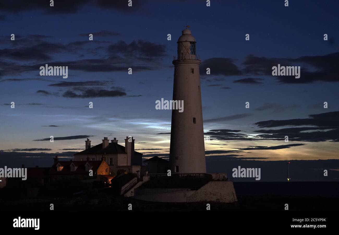 Nuvole o nuvole notturne noctilucenti che si formano dietro il faro di St Mary a Whitley Bay. Le nuvole appaiono quando il sole è 6-16 gradi sotto l'orizzonte. Foto Stock