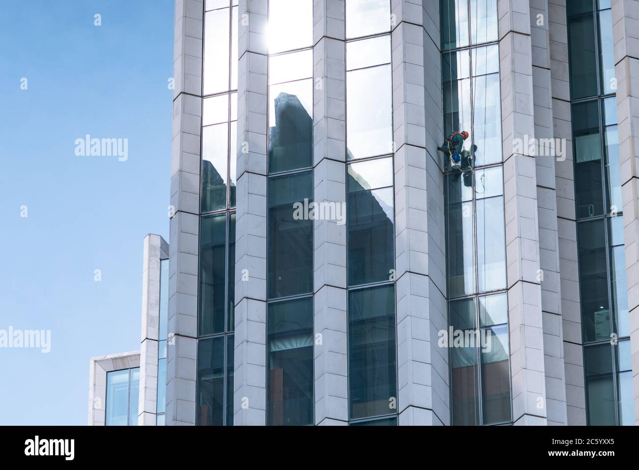 I panni in vetro lavorano sulla facciata di un moderno grattacielo a Shanghai, Cina. Foto Stock