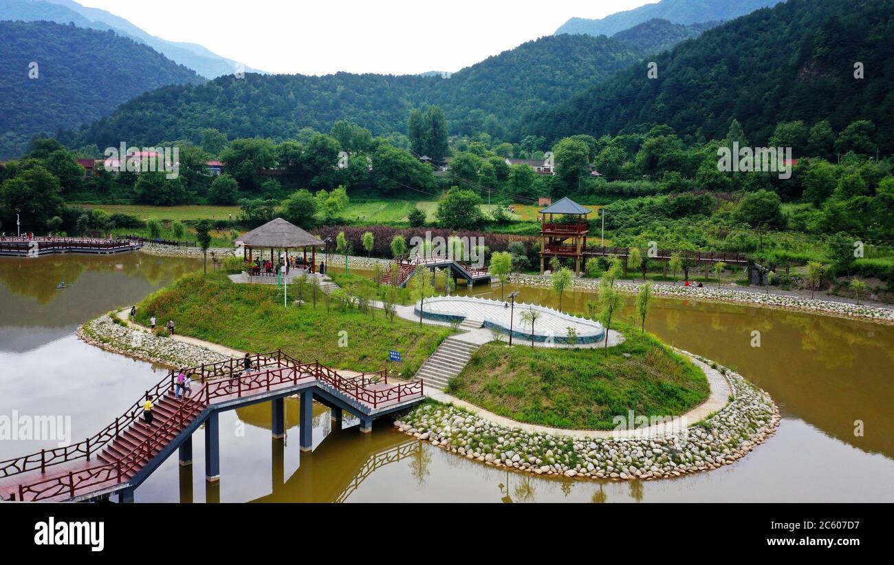 Taibai. 5 luglio 2020. La foto aerea scattata il 5 luglio 2020 mostra le persone che visitano il Villaggio di Baiyun, nella Contea di Taibai, nella provincia di Shaanxi, nella Cina nord-occidentale. Baiyun Village, situato nel profondo delle montagne Qinling, era da tempo un'area sottosviluppata con persone che vivono in povertà. Negli ultimi anni, promuovendo il turismo rurale e i prodotti agricoli, il villaggio ha tolto dalla povertà tutta la sua popolazione. Credit: Liu Xiao/Xinhua/Alamy Live News Foto Stock