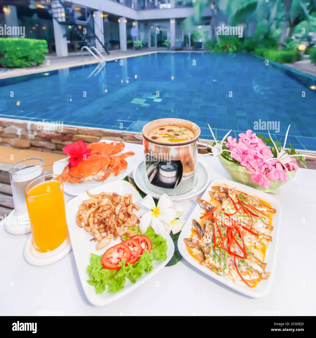 Il lussuoso resort propone pesce asiatico con piscina sullo sfondo, zuppa di gamberi e limongrass con funghi, pesce fritto al curry, gamberi. Foto Stock