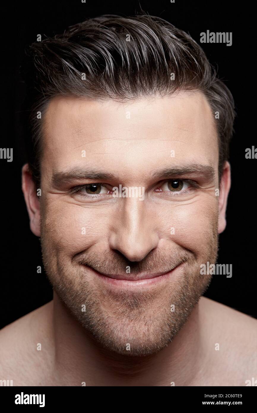 Ritratto di un uomo sorridente su sfondo scuro Foto Stock