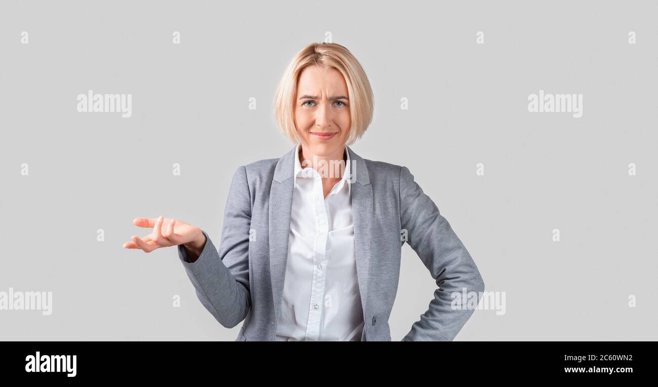 Il boss maturo della signora perplesso chiede la spiegazione su sfondo chiaro Foto Stock
