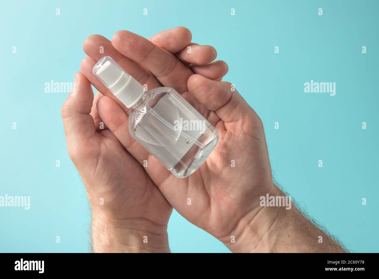 Mani che tengono disinfettante antibatterico spray, salute e igiene concetto Foto Stock