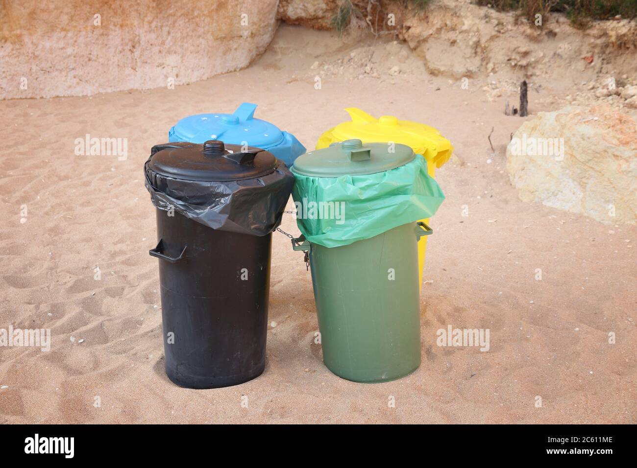 Contenitori per la smistamento dei rifiuti presso una spiaggia pubblica di Algarve, Portogallo. Concetto di riciclaggio europeo. Foto Stock