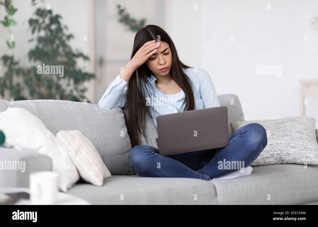 Stress freelance. Ragazza asiatica interessata stanca dopo il lavoro su un computer portatile a casa Foto Stock