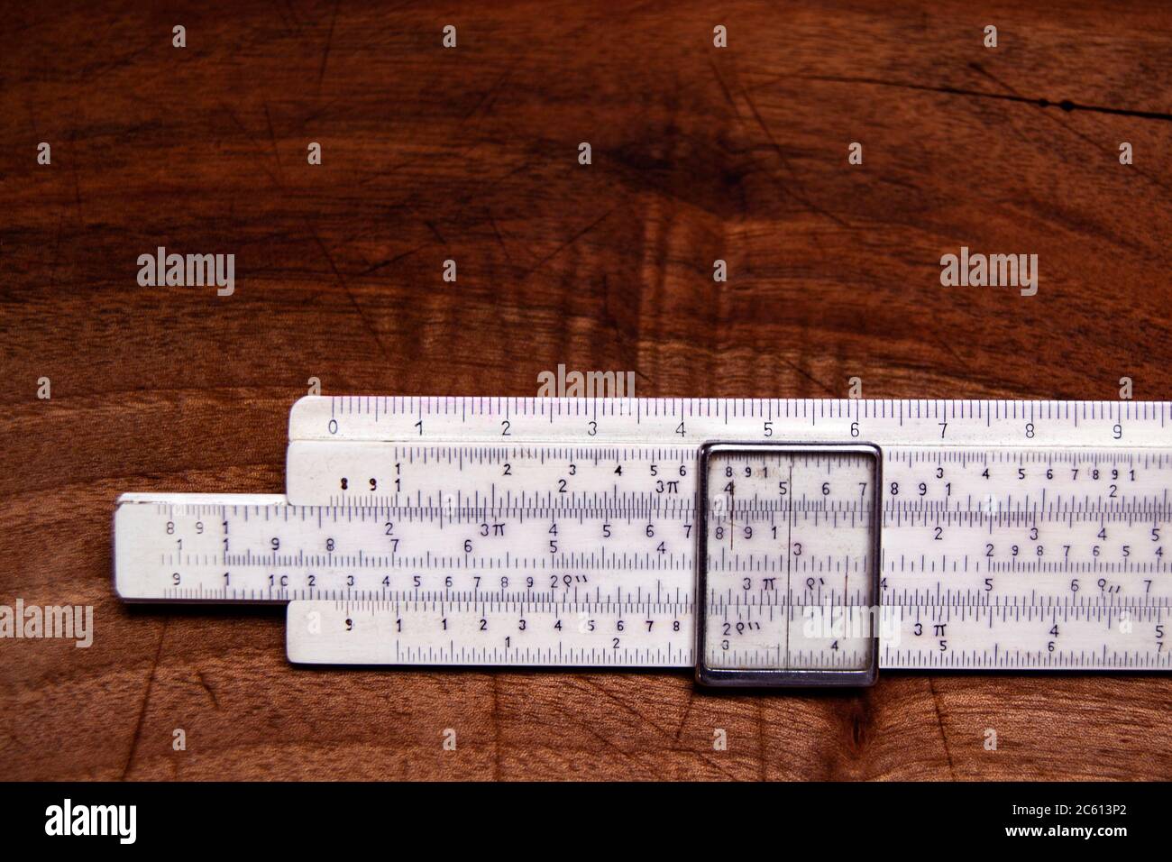 vecchia regola di scorrimento per il calcolo manuale su un banco di lavoro in legno background. concetti di educazione e scienza Foto Stock