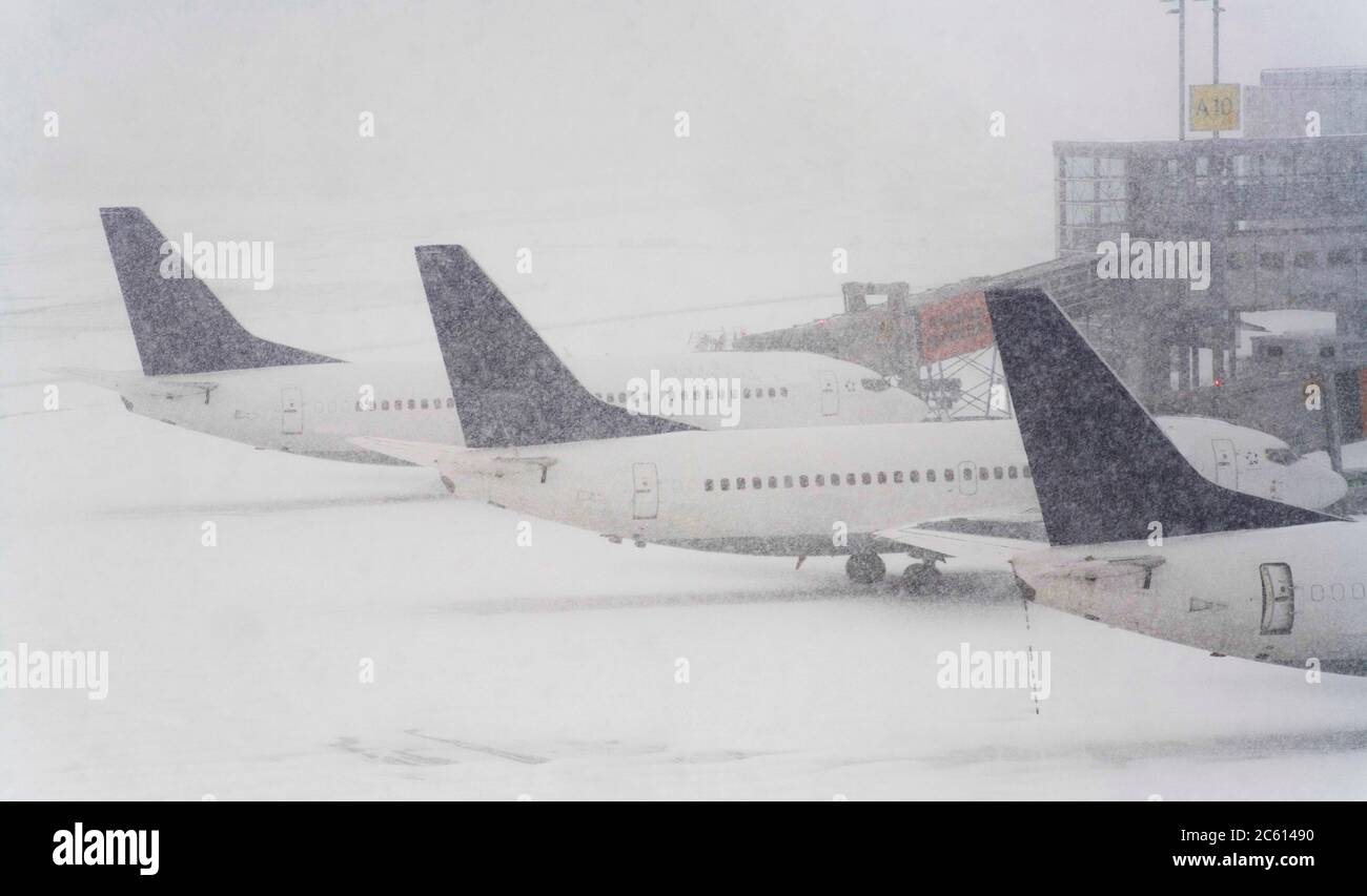 Blizzard su un aeroporto internazionale, aerei in attesa nella neve Foto Stock