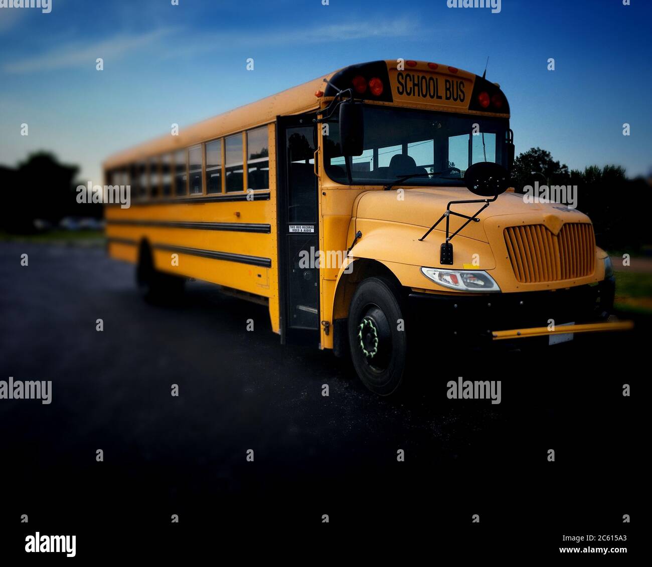 Vista ad alto angolo del lato destro della porta anteriore destra dell'autobus pubblico americano giallo comunemente usato per trasportare i bambini a scuola, viaggi sul campo e extra circolare e Foto Stock