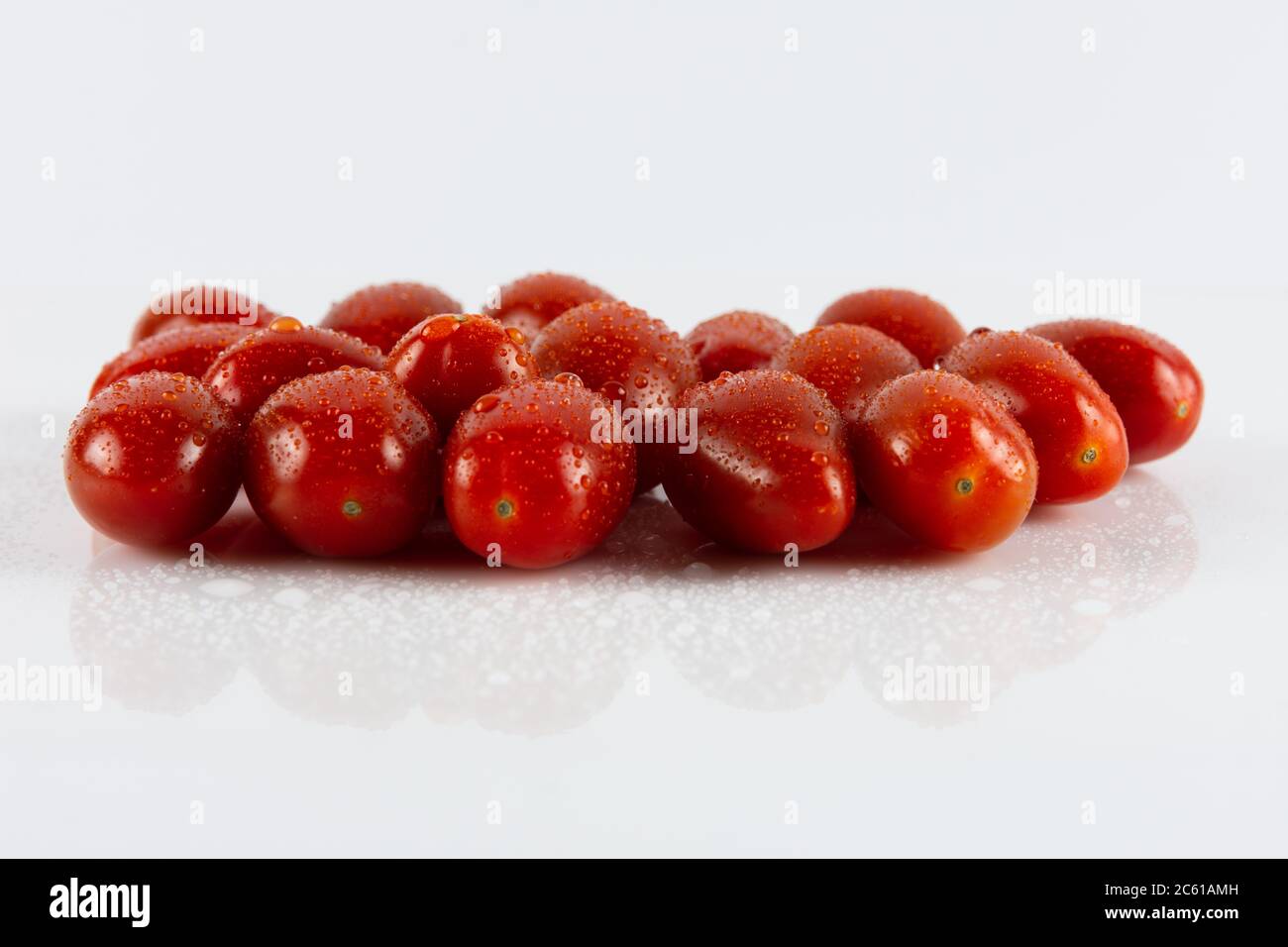 Alcuni pomodori freschi da cocktail maturi con pentole d'acqua Foto Stock