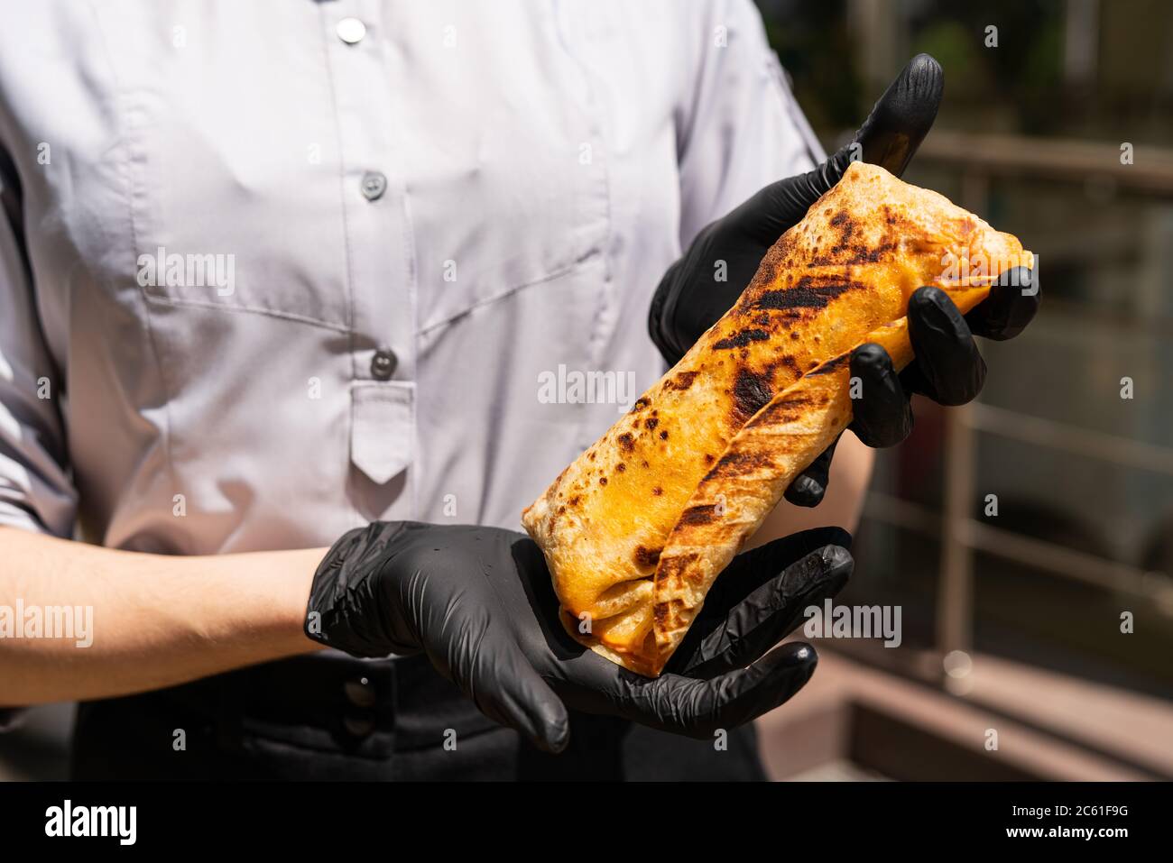 Burrito, shawarma agnello - il miglior cibo di strada. Primo piano di chef donne con shawarma. Foto Stock