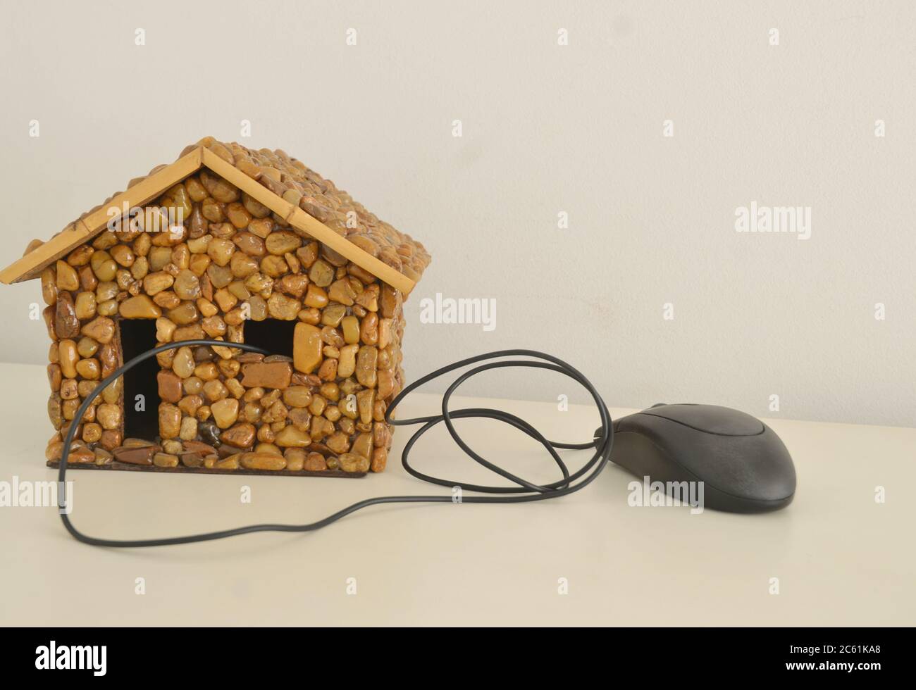 Casa in pietra o masso con computer accessorio, mouse, foto concettuale, Brasile, Sud America Foto Stock