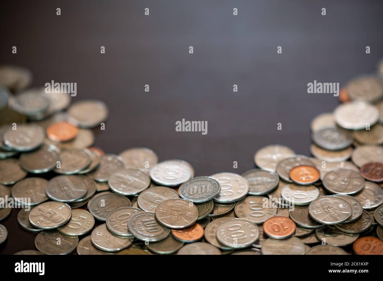 monete e spazio per la copia accatastati sulla scrivania. Foto Stock