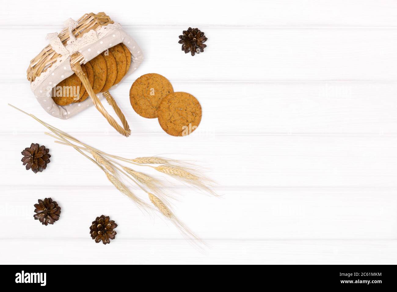Biscotti interi di grano con spighe di grano su tavola di legno bianco. Vista dall'alto, disposizione piatta. Cibo sfondo autunno in stile rustico Foto Stock