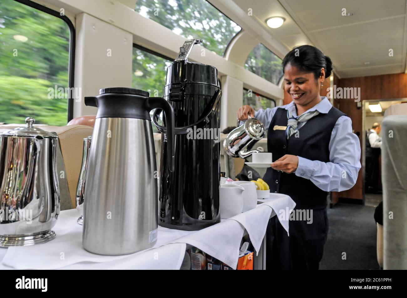 Un assistente di auto-ristorante che serve caffe' e te' a bordo del treno Rocky Mountaineer nella British Columbia, Canada Foto Stock