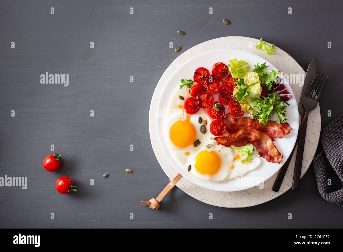 Sana dieta cheto colazione: uova, pomodori, foglie di insalata e pancetta Foto Stock